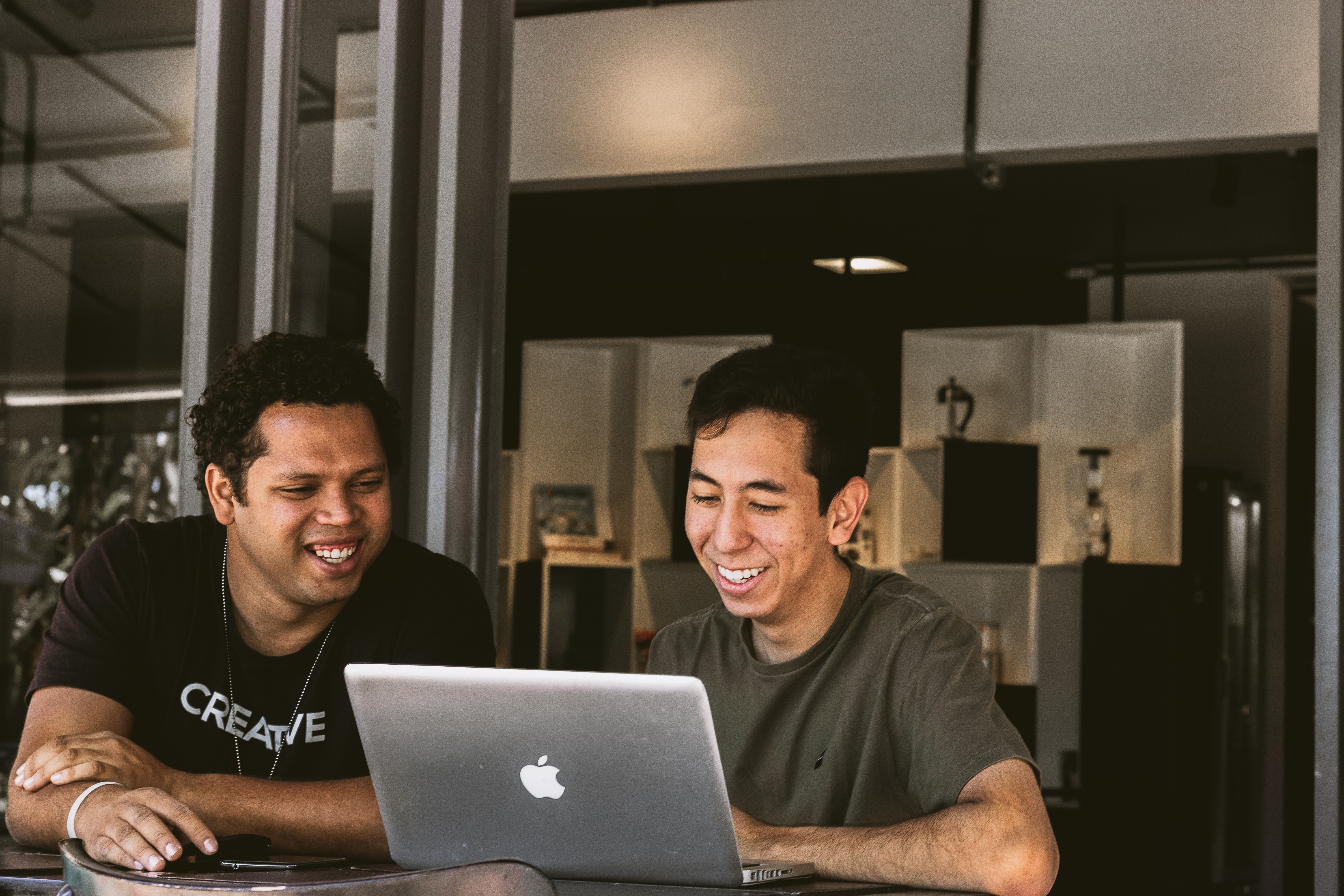 two asian men sharing laptop