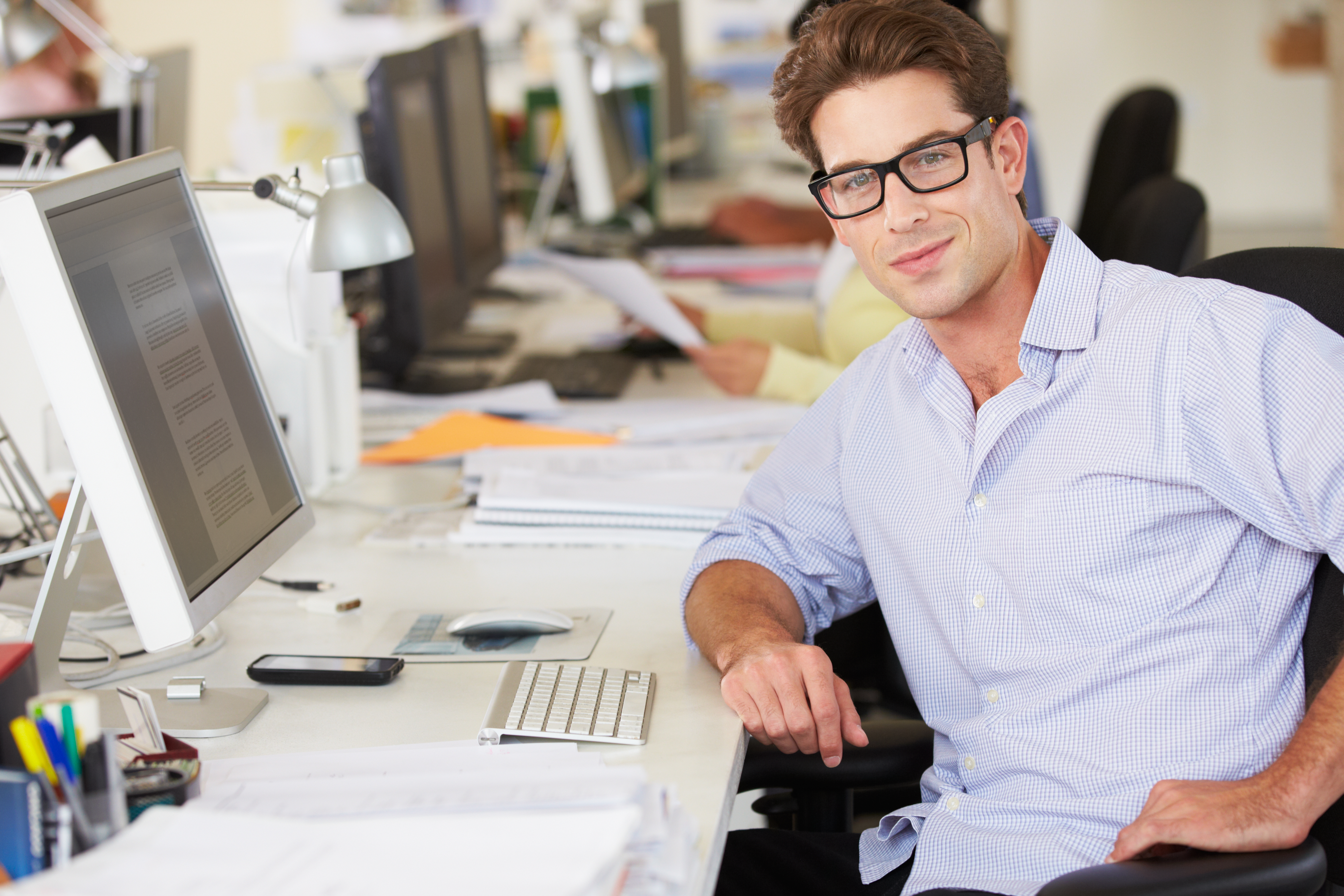 man with glasses working at computer